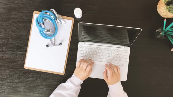 Top View of Female Doctor Hands Typing on Laptop