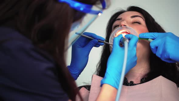 Professional Woman Dentist in Medical Gloves Examines Patient in Dental Clinic alt