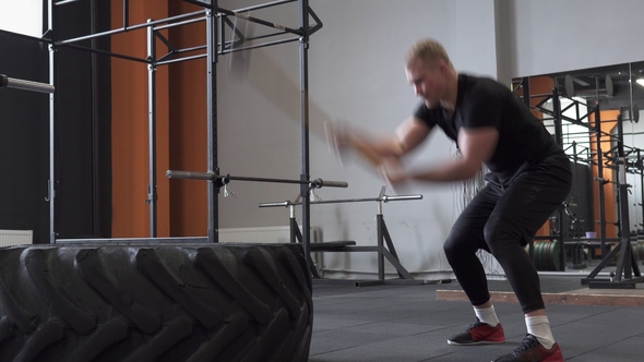 Fitness Man Doing Sledgehammer Swing Exercise in Gym alt