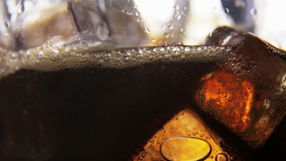 Ice Cubes in a Glass of Coke and Bubbles Rising