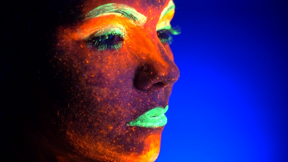 Portrait of Fashion Model Woman with Braids in Neon Light. Fluorescent Makeup Glowing Under UV alt