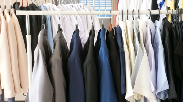 Different Male Business Clothes, Including Suits and Shirts on a Hanger alt