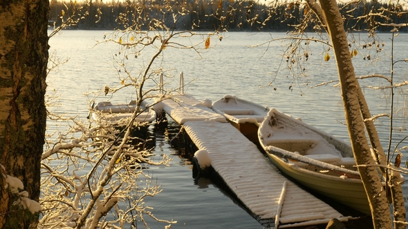 Snowy Boats Docked on Winter Lake