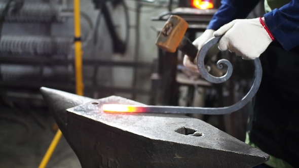 Slide Shot of Blacksmith Who Shapes Hot Steal with a Hammer