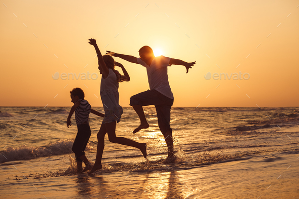 Father son and daughter playing on the beach at the sunset time. - Stock Photo - Images