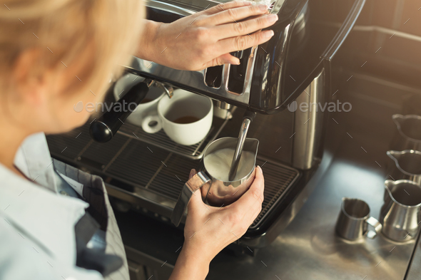Experienced barista steaming milk in professional coffee machine Stock Photo by Milkosx