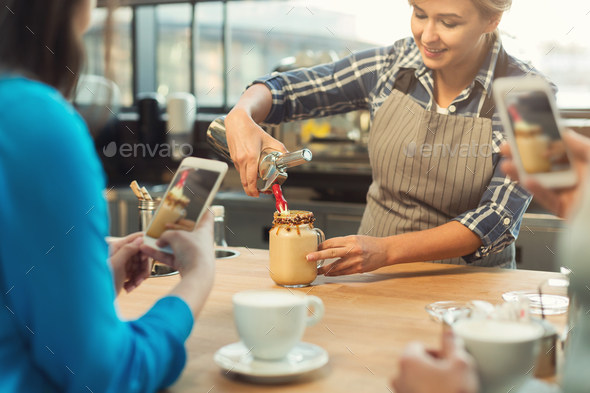 Experienced smiling barista giving master class at coffee shop interior Stock Photo by Milkosx