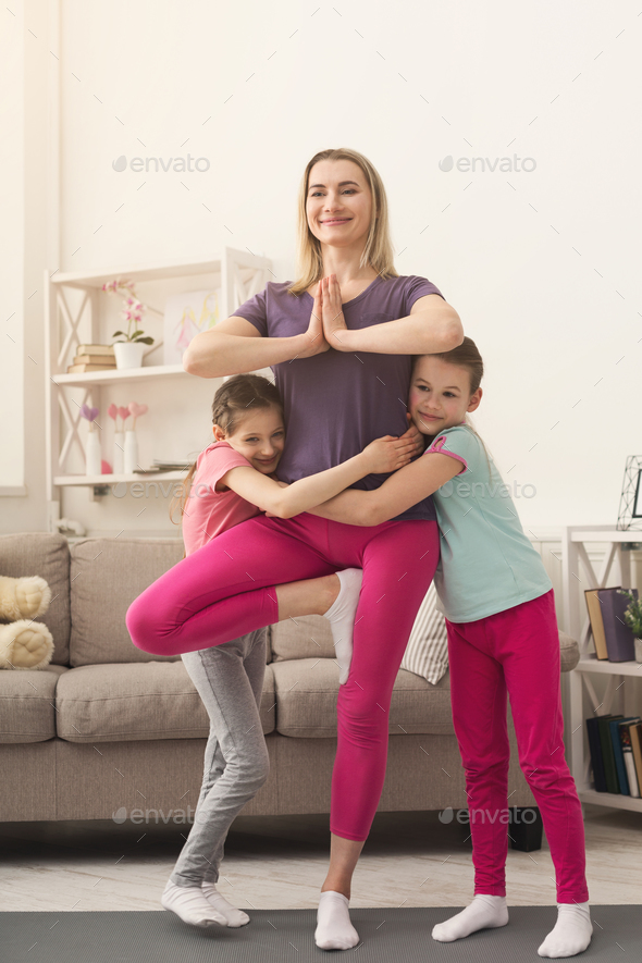 Young woman and child daughter training at home Stock Photo by Milkosx