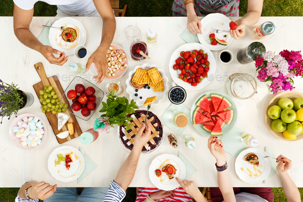 Multicultural group sharing food outside Stock Photo by bialasiewicz
