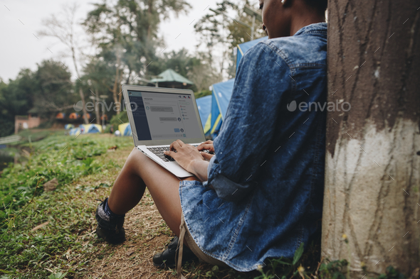 Woman alone in nature using a laptop on a camp site getaway from work or internet addiction concept Stock Photo by Rawpixel