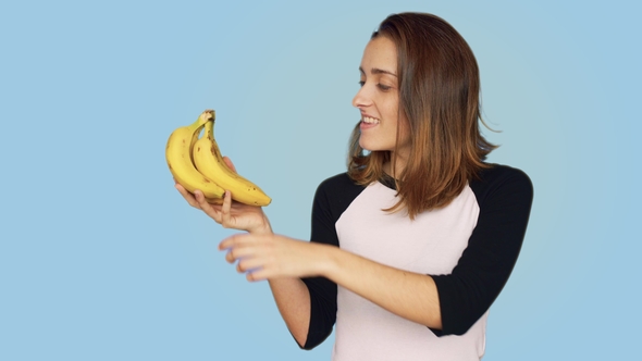 Pretty Smiling Woman Holds Bunch of Bananas