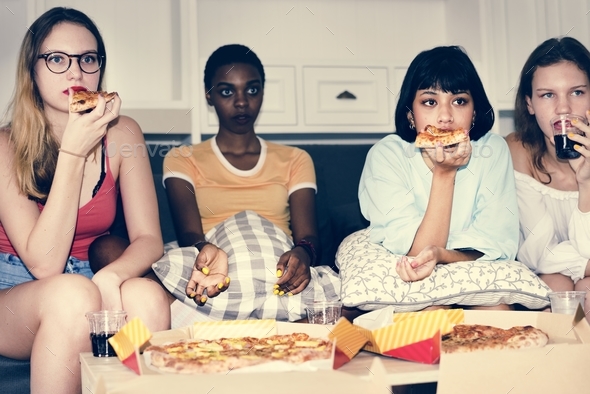 A diverse group of women sitting on the couch and eating pizza together Stock Photo by Rawpixel