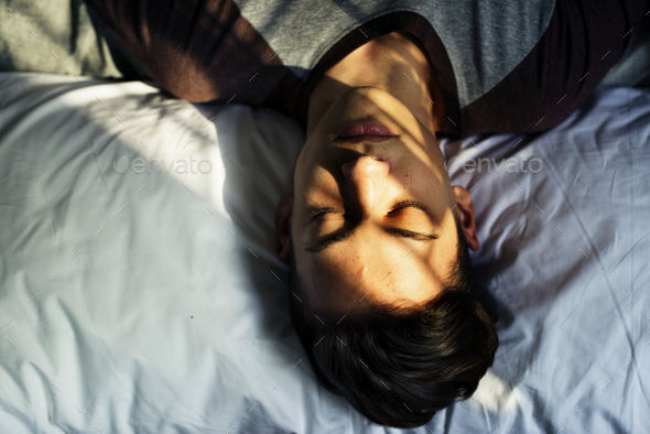 Teenage boy lying down on bed sleepy nap and depression concept Stock Photo by Rawpixel