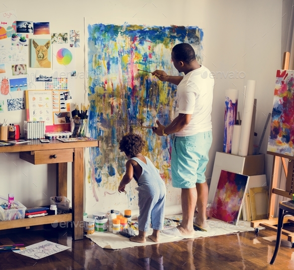 Black artist dad doing his art work with his child sitting nearby Stock Photo by Rawpixel