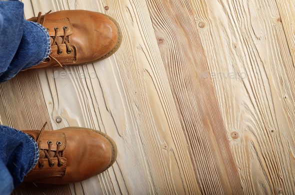 Carpenter feet in work boots standing on wooden floor. Place for Stock Photo by d_mikh