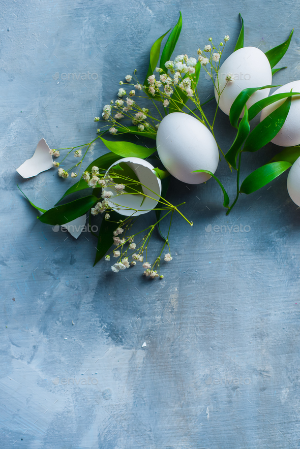 Overhead Easter background with white eggs, decorative green leaves and ...