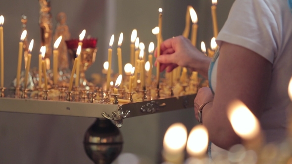 Woman's Hand Who Lights a Candle in the Temple