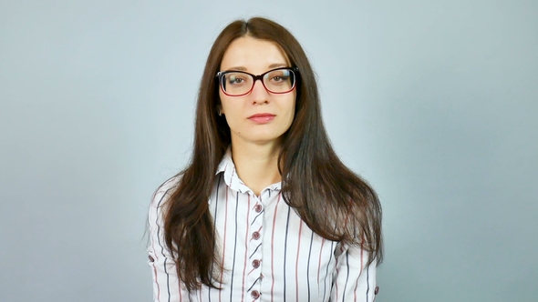 Serious Young Girl in White Shirt with Red and Blue Stripes Looking at the Camera Over Her
