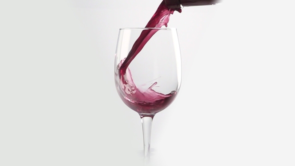 Pouring Red Wine Into the Glass Against White Background.