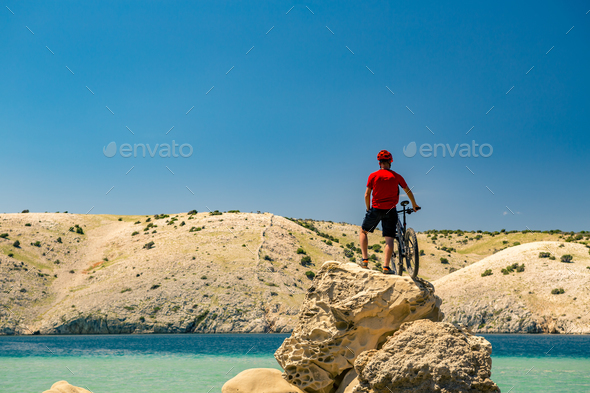 Mountain biker looking at mountains and beach Stock Photo by blas | PhotoDune