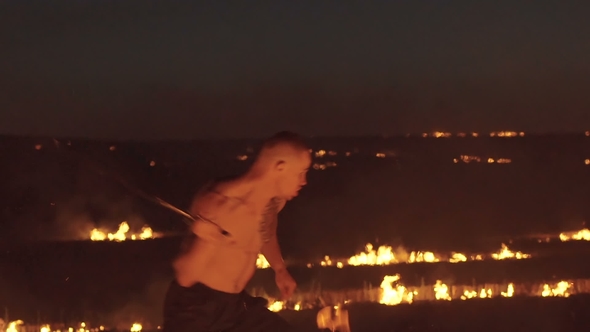 Free Fighter Training with Sword in the Burning Night Field. Slowly alt