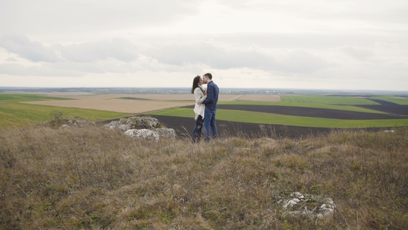 Lovely Couple in Embracess Looking on Nature From the Top of a Rock. alt