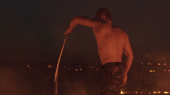 Free Fighter Training with Sword in the Burning Night Field. Slowly alt