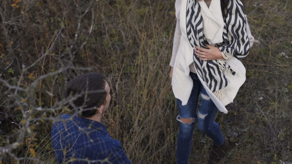 Top View of Cute Girl Comes To Her Man, Embraces and Kisses Him. alt