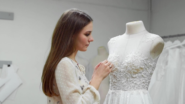 Girl Creating a Wedding Dress by Exclusive Order Sewing Fabrics and Rhinestones alt
