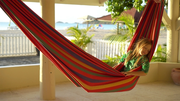 Adorable Little Girl on Tropical Vacation Relaxing in Hammock alt