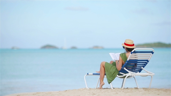 Young Woman Reading Book during Tropical White Beach