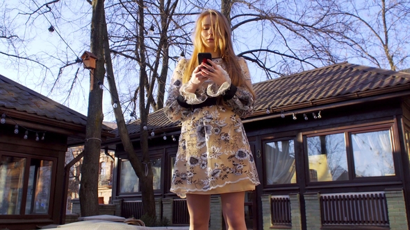 A Girl Reads Messages in Her Mobile Phone