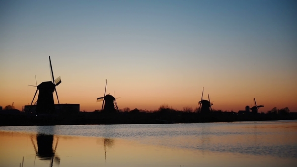 Traditional Dutch Windmills at Sunset From the Channel Rotterdam. Water Mirror Effect. Holland