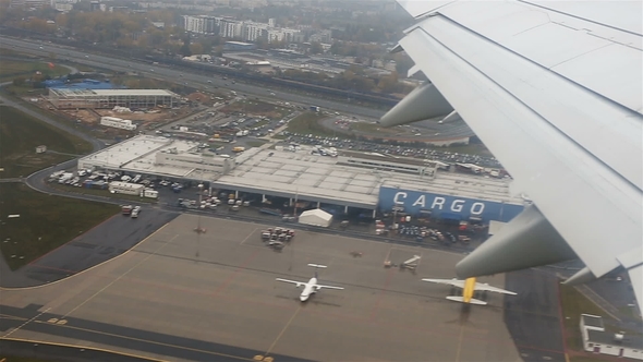 View Through an Airplane Window Flying Over the City Through Clouds