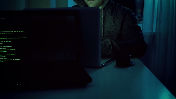 Footage of Young Male Hacker in Hoodie Working on Laptop at Home in Night. Perfect Video for Cyber