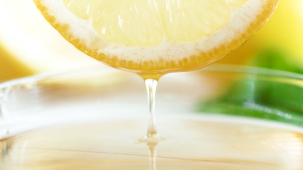 Footage of Fresh Juice Slowly Flowing From Lemon Slice