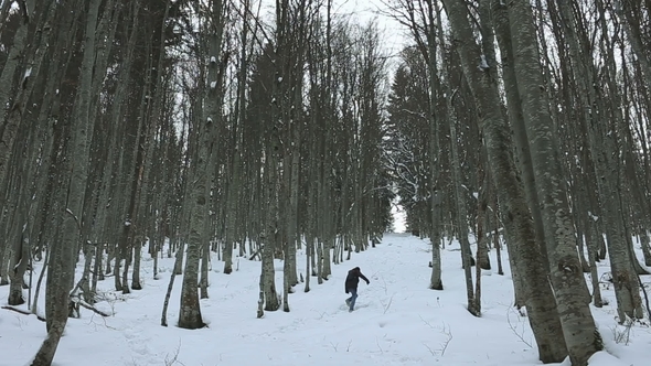 Man Goes Up the Hill in the Woods at Winter