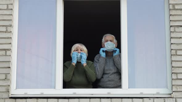 Old Grandparents Stay at Window Isolated at Home on Quarantine. Coronavirus alt