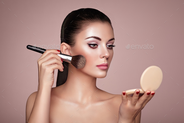 Beautiful Woman applies Skin Tone with Brush Stock Photo by heckmannoleg