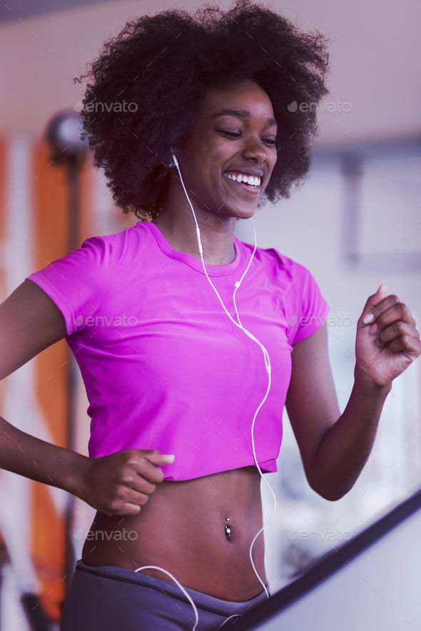 afro american woman running on a treadmill Stock Photo by dotshock