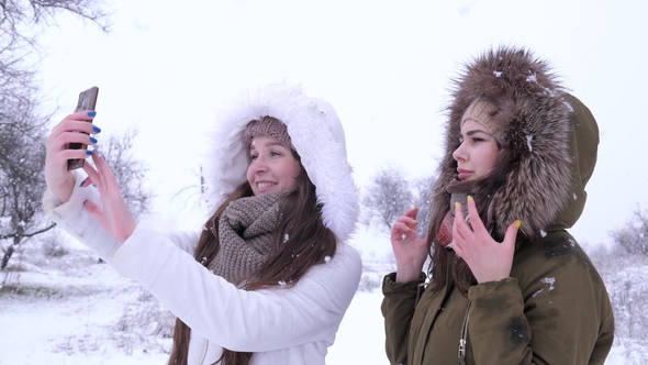 Girlfriends Make an Air Kiss for Photos on Gadget in Winter Time, Stock ...