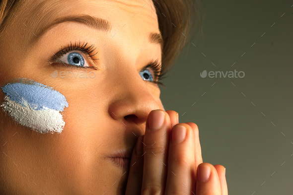 Portrait of a woman with the flag of the Argentina painted on her face. - Stock Photo - Images