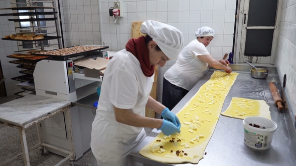 Traditional Italian Bakery. Two Female Bakers Prepare Sweet Buns with Cream Pasticcera, Raisins alt