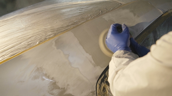 The Grinding Primered Car Surface with Grind Machine. alt