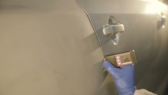 Measuring a Thickness of Primer on a Car Surface Using a Thickness Gauge alt