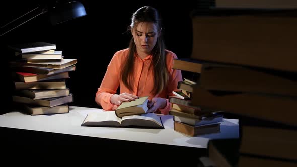 Girl Goes Through the Book and Find the Right Information. Black Background alt