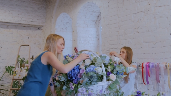 Two Women Florists Making Large Floral Basket with Flowers at Flower Shop