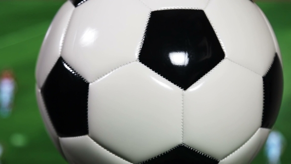 the Soccer Ball Is Spinning on the Background of the Football Match