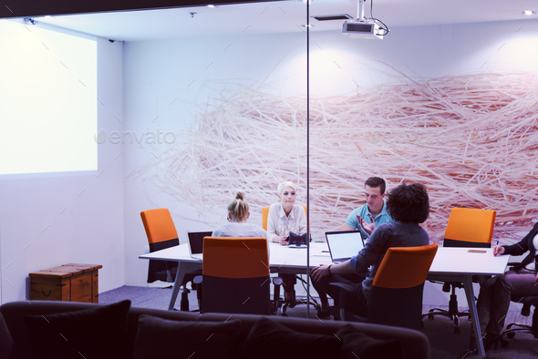 Startup Business Team At A Meeting at modern night office buildi Stock Photo by dotshock