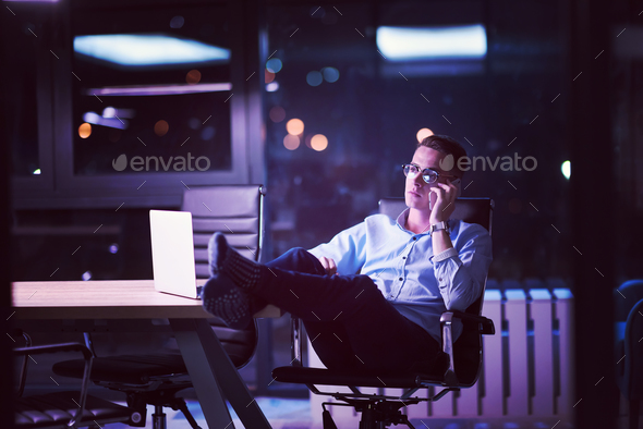 businessman using mobile phone in dark office - Stock Photo - Images